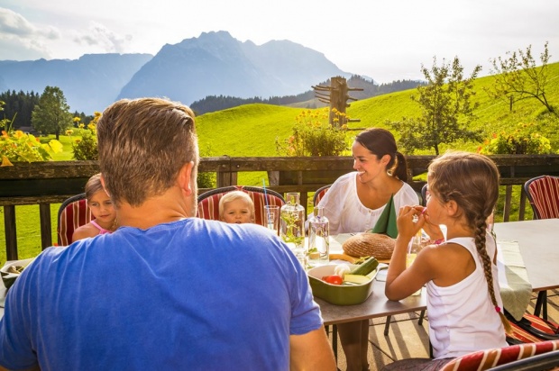 Familie auf der sonnigen Terrasse am Bio-Berggasthof Bachrain (© Urlaub am Bauernhof)